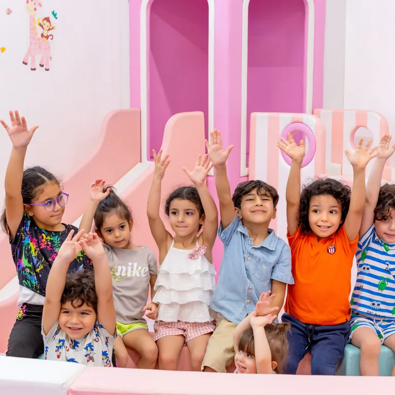 أطفال يرفعون أيديهم فرحًا أثناء اللعب في المركز