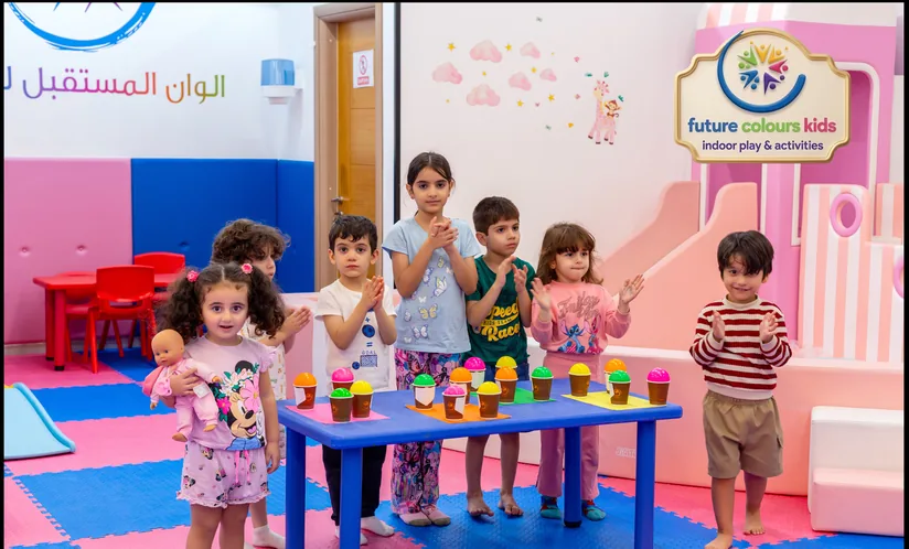أطفال حول طاولة الأنشطة اليدوية الملونة